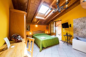 una camera con letto verde e soffitto in legno di Agriturismo il Porcellino a Quinto di Valpantena