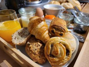 - un plateau de viennoiseries et de pain sur une table dans l'établissement B&B Le Bois de Champia, à Huy