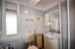 a bathroom with a sink and a toilet and a mirror at Wohnung in Novigrad mit privatem Parkplatz in Karpinjan