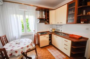 a kitchen with a table and a small kitchen with a sink at Wohnung in Novigrad mit privatem Parkplatz in Karpinjan +7 photos