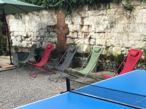 un groupe de chaises et de tables devant un mur dans l'établissement Maison 6 chambres, à Beauvais