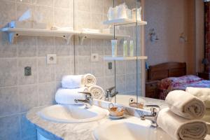 a bathroom with a sink and a mirror and towels at L'Hotel du Nord - Quarré-les-Tombes in Quarré-les-Tombes