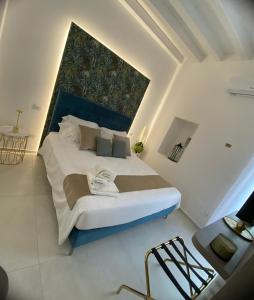 a bedroom with a large bed with a blue headboard at La Maison de Rosaline Rooms in Barletta