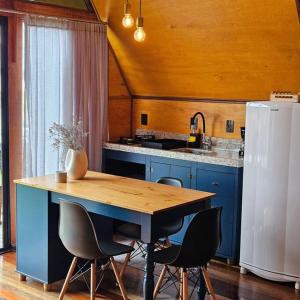 a kitchen with a wooden table and a refrigerator at Chalé de Campo com hidro in Campo Alegre