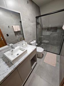a bathroom with a sink and a shower and a toilet at Chalé de Campo com hidro in Campo Alegre