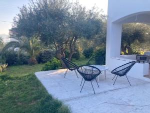 3 sillas negras sentadas en un patio con una mesa en CozyStudio, en Chalkida