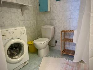 a bathroom with a toilet and a washing machine at CozyStudio in Chalkida