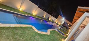 a swimming pool with stairs next to a house at night at Chalés Mar e Sol in São Miguel do Gostoso +32 photos