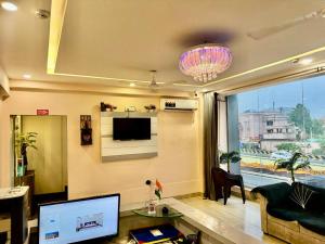 Una sala de estar con un sofá y un televisor. en HOTEL SILVER STONE INN, en Lucknow