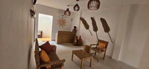 a living room with a couch and chairs and a guitar at Chalés Mar e Sol in São Miguel do Gostoso