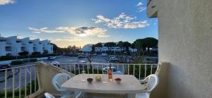 einen Tisch auf einem Balkon mit Straßenblick in der Unterkunft Terrasses 2 - Plage et commerces à 400 m in Le Grau-du-Roi