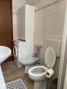 Un baño con un inodoro blanco y un lavabo. en Tiny House Valbondione [wi-fi], en Valbondione 20 fotos más