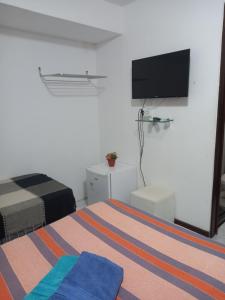 a bedroom with a bed and a flat screen tv at Pousada Aconchego do Tambaú in João Pessoa