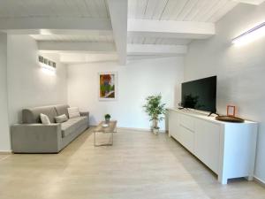 a living room with a couch and a flat screen tv at Guendalina in Santa Teresa Gallura