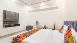 a bedroom with a bed and a flat screen tv at HOTEL SILVER STONE INN in Lucknow