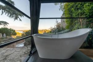 Cette chambre dispose d'une baignoire et d'une grande fenêtre. dans l'établissement Sublime 180° d'Avignon Villeneuve Ventoux Alpilles, à Villeneuve-lès-Avignon