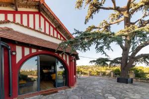 - un bâtiment rouge et blanc avec une grande fenêtre dans l'établissement Sublime 180° d'Avignon Villeneuve Ventoux Alpilles, à Villeneuve-lès-Avignon