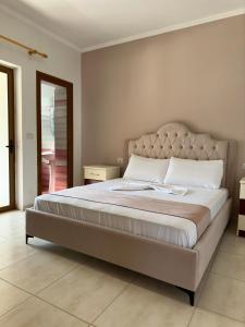 um quarto com uma cama grande num quarto em Evelina Ernild Rooms em Saranda
