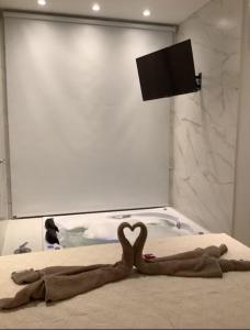 a heart shaped blanket on a bed with a bath tub at Águas do Manso Hotel E Marina in Chapada dos Guimarães