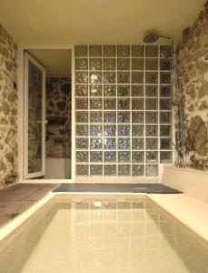 a swimming pool with a wall of glass bottles at El jazmín de la Fuente casa rural in Guijo de Santa Bárbara