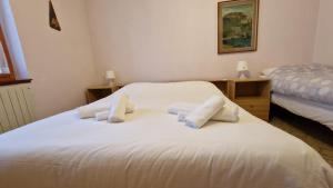 a bedroom with a white bed with towels on it at Borno Good Stay! in Borno