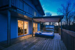 a porch with a bed on a deck at Chalet Le Pélican in Lac-Superieur