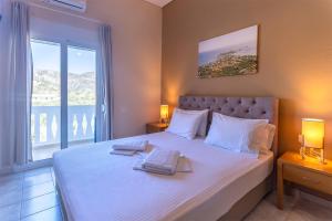 a bedroom with a large bed with two towels on it at Oriental Bay in Palaiochóra