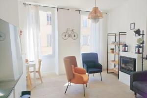 ein Wohnzimmer mit 2 Stühlen und einem Kamin in der Unterkunft Chic And Modern Apt 5 Min From The Beach in Marseille