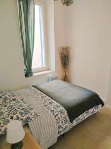 Schlafzimmer mit einem Bett und einem Fenster in der Unterkunft Chic And Modern Apt 5 Min From The Beach in Marseille