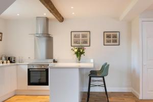 a kitchen with a counter with a vase of flowers on it at The Hop Kiln in Leominster