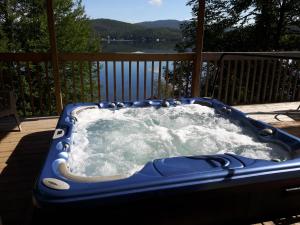 a blue hot tub on a deck with water at Chalet Le Pélican in Lac-Superieur