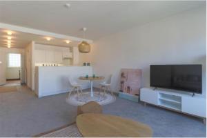 een woonkamer met een tafel en een televisie en een keuken bij Lichtrijke studio in Kortrijk