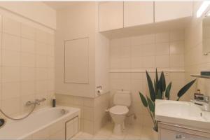 een badkamer met een toilet, een wastafel en een bad bij Lichtrijke studio in Kortrijk