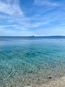 a beach with clear water and an island in the distance at Podere Il Ritorno in Portoferraio