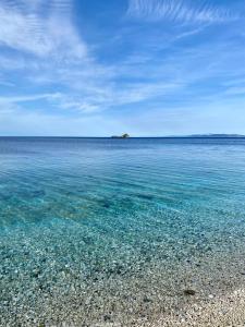 una spiaggia con acqua limpida e un'isola in lontananza di Podere Il Ritorno a Portoferraio