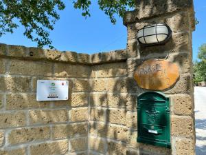 a wall with a green mailbox and a street light at Podere Il Ritorno in Portoferraio