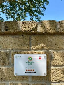 a sign on the side of a brick wall at Podere Il Ritorno in Portoferraio