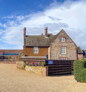 a large brick house with flowers in front of it at Caley in Hunstanton