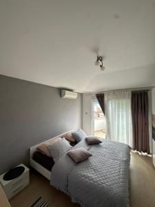 - une chambre avec un lit doté d'oreillers et d'une fenêtre dans l'établissement Vila Damir, à Gradac