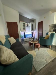 un salon avec un canapé bleu et une télévision dans l'établissement Vila Damir, à Gradac