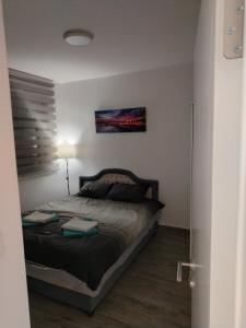 1 dormitorio con 1 cama y una pintura en la pared en Divčibarski Vidik, en Divčibare