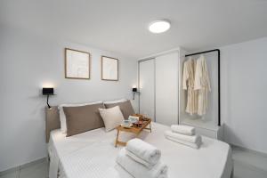 una camera da letto con un letto con asciugamani sopra di Aelia Elegant Apartments a Kalamáta Altre 38 foto