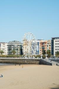 a beach with a ferris wheel in the background at Hotel Niza in Donostia-San Sebastián