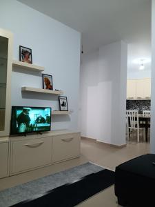 a living room with a flat screen tv on a dresser at Diamond Apartment Vlore in Vlorë