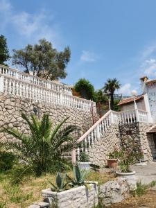 a stone wall with a white fence and a staircase at Samo Skreneš in Brežani
