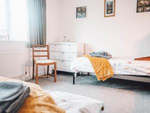 a bedroom with two beds and a chair and a dresser at Chalkhill View - Idyllic Sea Views Parking in Wyke Regis