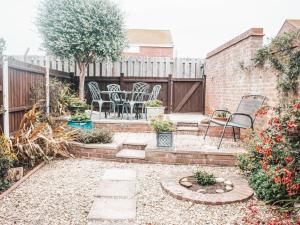 a backyard with chairs and a table and a fence at Chalkhill View - Idyllic Sea Views Parking in Wyke Regis