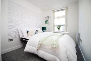 um quarto branco com uma cama grande e uma janela em 2BR Near City centre em Bristol