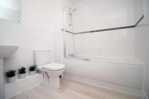 uma casa de banho branca com um WC e uma banheira em 2BR Near City centre em Bristol