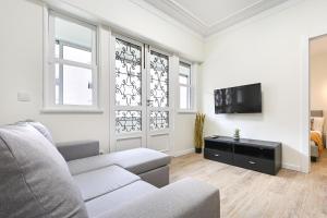 een woonkamer met een bank en een tv bij Sé Apartamentos - Largo da Estação Apartments in Braga